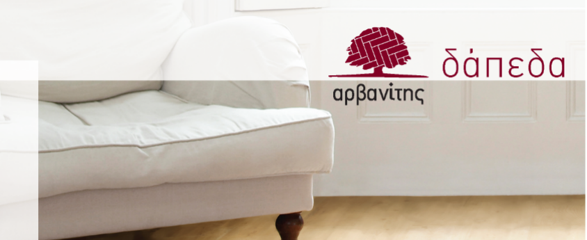 Η φωτογραφία απεικονίζει έναν καναπέ επάνω σε λευκό ξύλινο μασίφ δάπεδο και το λογότυπο της εταιρίας Αρβανίτης Δάπεδα
